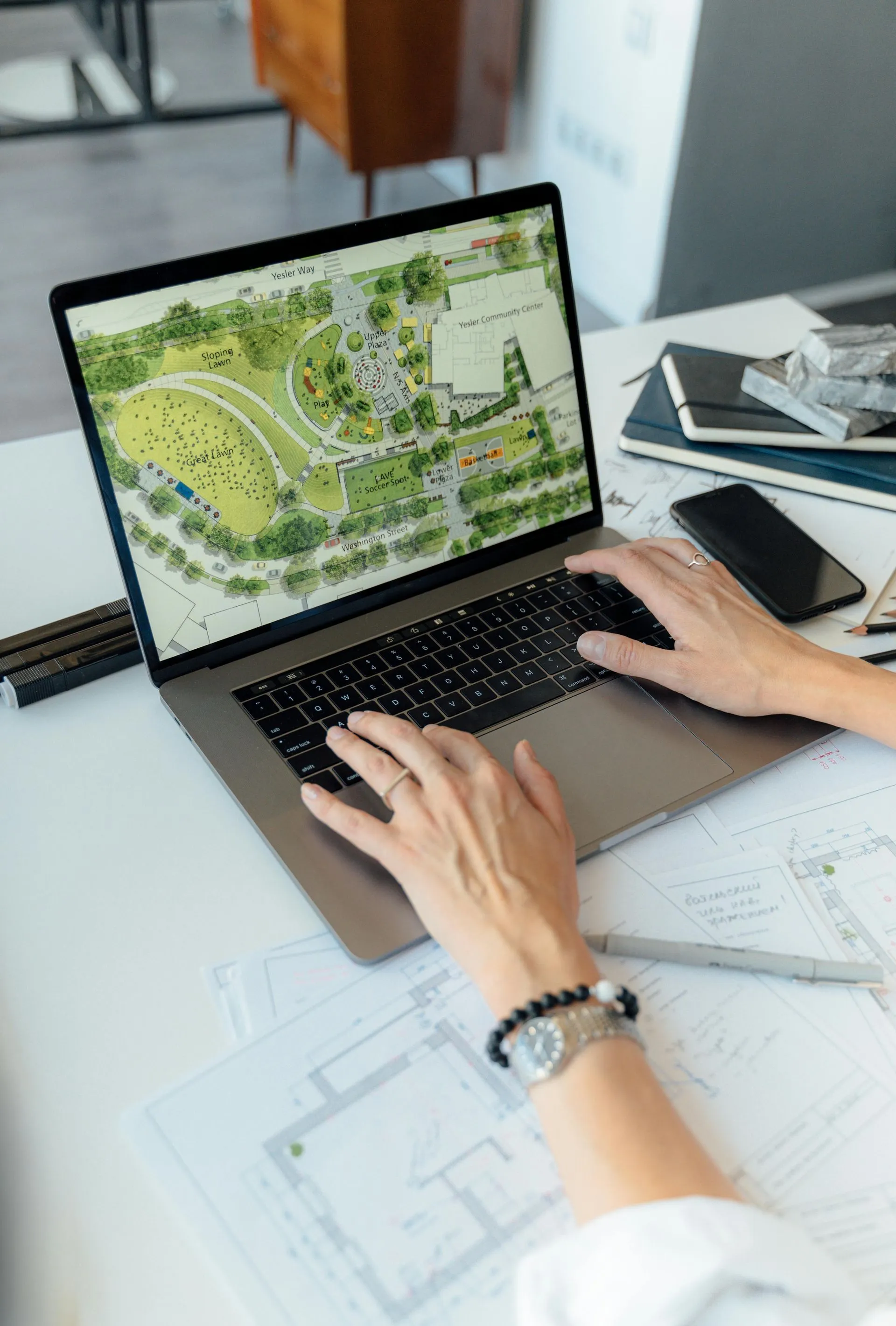 Designer using ChatGPT with concept board materials nearby