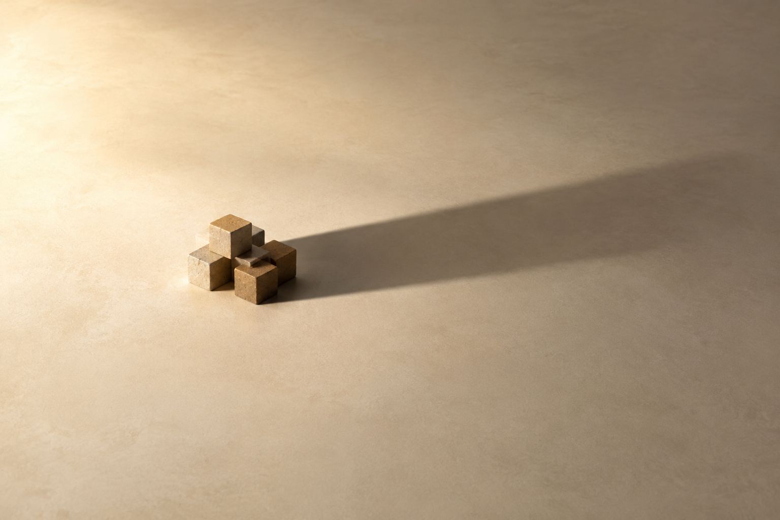 Small cluster of stone cubes casting one long unified shadow